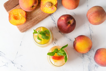 Glasses of tasty peach juice on white background