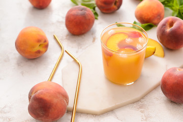 Glass of tasty peach juice on table