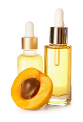 Bottles of apricot essential oil on white background