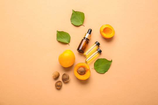 Bottles Of Apricot Essential Oil On Color Background