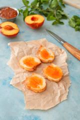 Bread slices with tasty peach jam on color background
