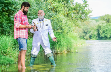 Fototapeta premium Summer weekends or vacation. Fishing excuse drinking. Bearded man and elegant businessman fishing together. Cheers. Men relaxing nature background. Fun and relax. Weekend time. Fishing skills
