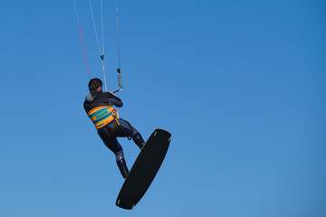 Kitesurfer in the jump on a background of high mountains, kitesurfer board with copy space for advertising