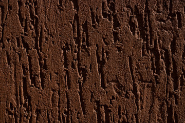 Decorative relief adhesive plaster. Brown stucco wall. The brown background of the wall.