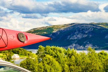 Car with canoe on top roof in mountains