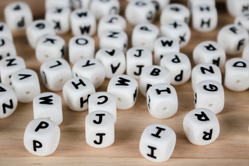 Text dice cube concept / Letter dices alphabet on wooden background. Block of alphabet studded on...