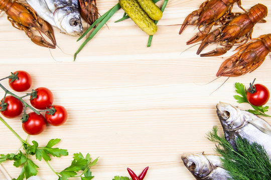 Composition with crayfish, dry fishes, pepper, tomatoes, dill, parsley, pickled cucumbers. Cooking food background with free space for text. Top view with copy space