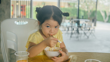 Portrait of asian little girl eating delicious noodles and soup.