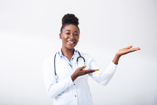 Doctor black woman, medical professional pointing in right direction isolated over white background. Female mature doctor with stethoscope