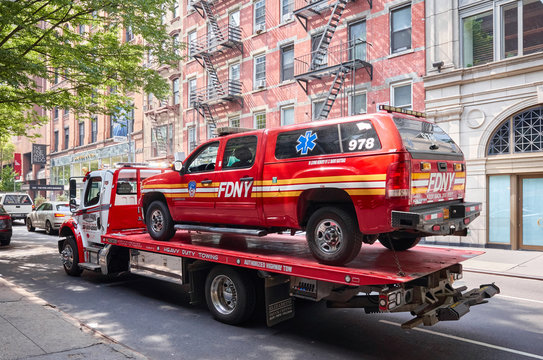 New York, USA - July 01, 2018: FDNY vehicle being transported on a tow truck on a street of Manhattan.