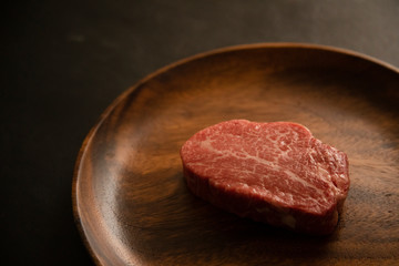 Raw meat on the wooden plate
