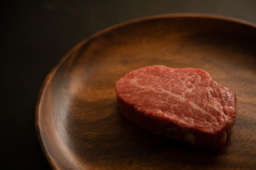 Raw meat on the wooden plate