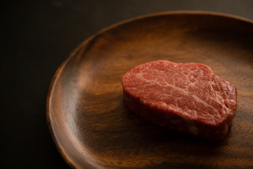 Raw meat on the wooden plate
