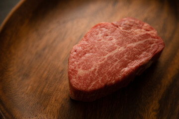 Raw meat on the wooden plate