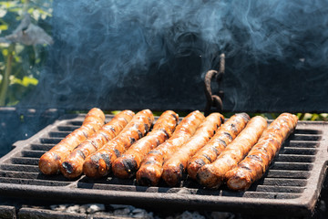 Sausages on the charcoal. BBQ outdoor. Fried meat sausages