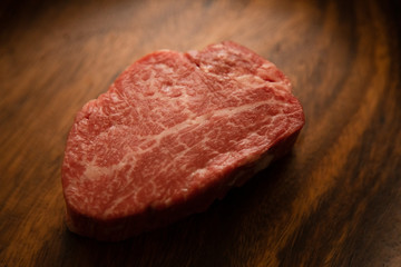 Raw meat on the wooden plate