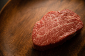 Raw meat on the wooden plate