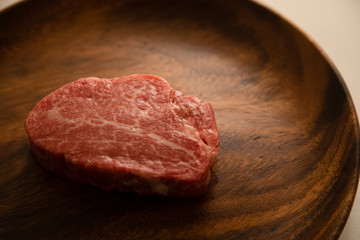 Raw meat on the wooden plate