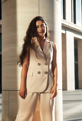 young pretty brunette woman in fashion suit at business building posing cheerful, lifestyle people concept
