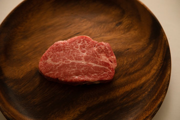 Raw meat on the wooden plate