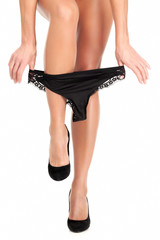 Sexy female legs. Woman is pulling her panties up. Isolated on white background