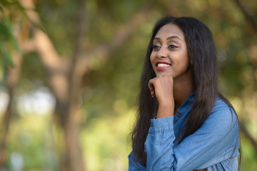 Happy young beautiful African woman at the park outdoors