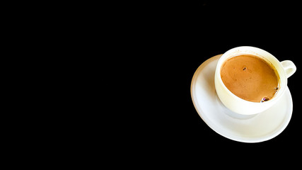 Milk refreshing morning coffee on white cup with black background. Asian morning coffee