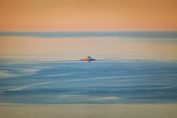 A lonely small island with a church in the middle of the Adriatic Sea at the colorful dawn of the day, Croatia, Europe.