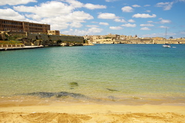 Fototapeta na wymiar View of Valletta from a sandy beach in Kalkara, Malta