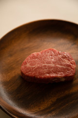 Raw meat on the wooden plate