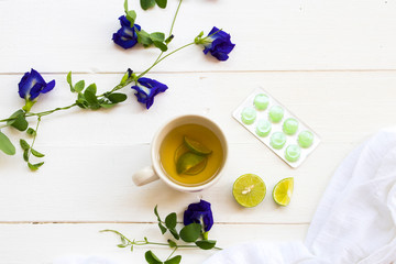 herbal healthy drinks honey lemon tea and cough sore throat pills with lemon slice ,blue flower...