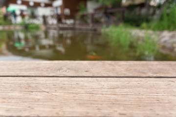 Wooden table top or shelf against water background. Montage with focus to the shalf in the foreground and product placement. Mock up