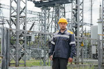 An engineering employee makes a tour and inspection of a modern electrical substation. Energy. Industry