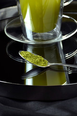 cucharada de te matcha sobre fondo negro entorno lujoso
