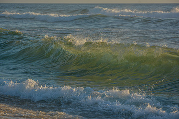 Huge wave backlit from the sun. Rough sea.