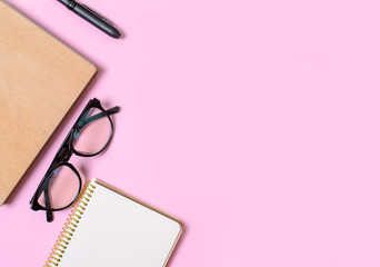 Pink background with notepad, office glasses, pen, place for text. Trend concept. Future. Business motivation,inspiration concepts