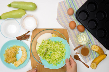 step by step recipe and ingredients for chocolate muffins with zucchini and banana. wet veggie cupcakes home-made, top view on a light background. the process of cooking muffins