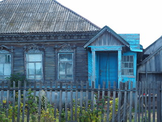 Wooden old house with a porch in a Russian village.