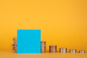  financial crisis. pile of coins with a graph for a fall.