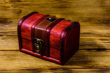 Closed vintage chest from red wood on wooden background