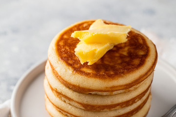 Classic pancakes with butter on light concrete background for breakfast.Close up