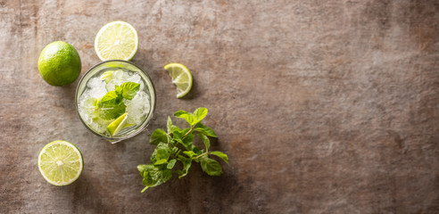 Mojito cocktail drink with white rum lime mint herbs and soda on the bar counter.