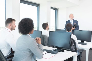 Businessman speaking in front of executives at seminar