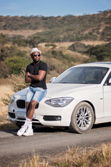 Successful black man with luxury car in the african safari