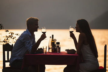 Couple is having a private event dinner on a tropical beach during sunset time