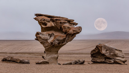 strange rock formation in the Salvador Dali desert area in Bolivia with full moon