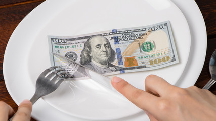 Dollars on a plate.Sawing through America's budget, the living wage, or the dual currency basket in the US.The crisis is caused by the fall in exchange rates.Dollar depreciation. Business and banking