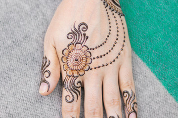 Woman Hand with brown mehndi tattoo. Hand of Indian bride girl with brown henna tattoos