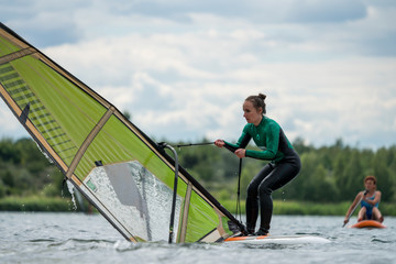 Woman learning windsurfing on a lake