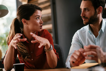 Colleagues in office. Businesswoman and businessman discussing work in office. Two friends in working together.